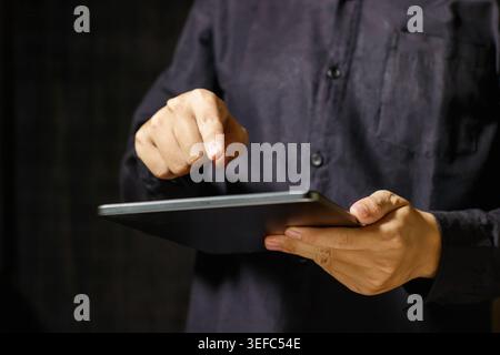 Man using a digital tablet with his finger on the screen. Close-up Man Gesture. Business and Technology Concept. High quality photo Stock Photo