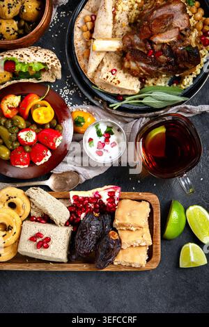 Middle eastern or Mediterranean dinner with falafel, roasted and fresh vegetables, assorted Arabic meze and appetizers on dark background. Top view. Stock Photo