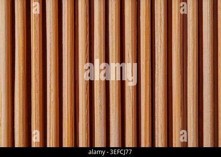 A detailed, abstract background showcasing the natural texture and grain of multiple wooden skewers lined up closely together Stock Photo
