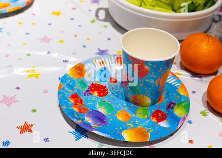 Festive table setting with painted plate and fruit, creative celebration decor, colorful party mood, family gathering. Stock Photo