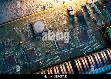 Detailed close-up of a printed circuit board showcasing various electronic components, chips, and circuitry used in modern electronic devices. Stock Photo