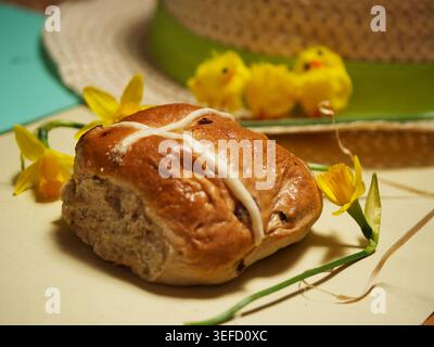 Easter hot cross bun with eggs and daffodil flowers yellow background Stock Photo