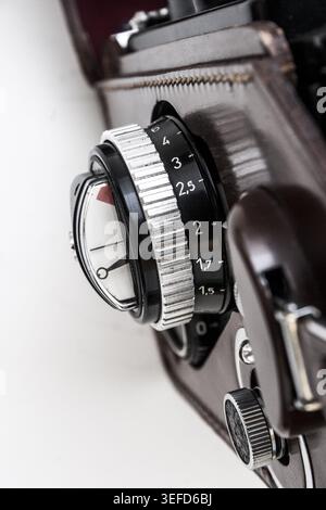 Macro detail of vintage film camera focus ring showing aperture numbers, depth of field scale and coupled exposure meter on a Rolleiflex 3.5F TLR. Stock Photo