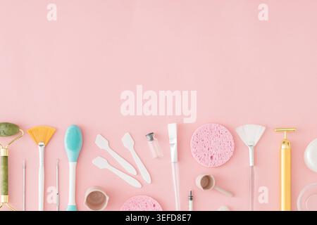 Trendy skincare composition with facial cleansing tools, beauty accessories and spa essentials on pastel pink background with copy space. Stock Photo
