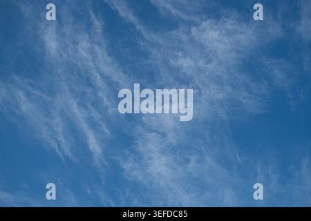 Thin cirrus clouds form a textured pattern across a clear blue sky. Stock Photo