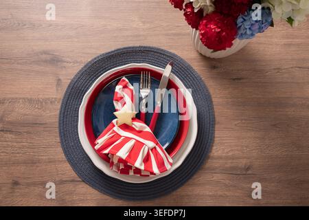 Elegant patriotic table setting with striped napkin and festive flowers for American Independence Day celebration. Stock Photo