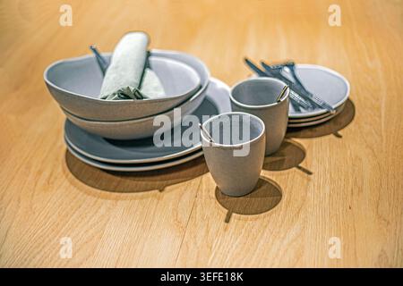 A stylish gray ceramic dinnerware set on the counter Stock Photo