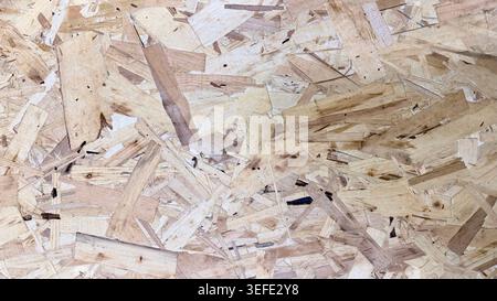 Close-up of OSB wood board texture with natural chip pattern and beige wooden surface. Stock Photo
