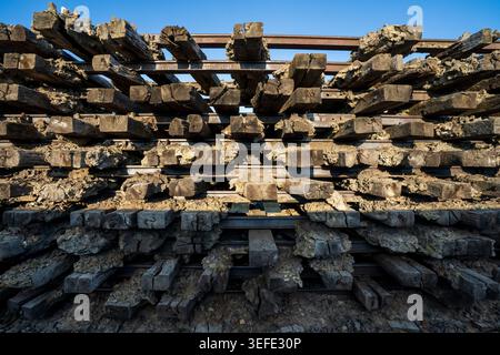 A dense close-up front shot shows the complex geometric framework of old worn wooden railway ties and overlapping rusted iron tracks, part of the memo Stock Photo