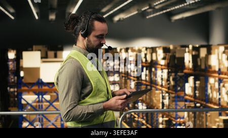 Customer support agent taking phone calls to ensure package tracking for shipment and delivery. Man checking logistics details and systems, representing large business supply chain operations. Stock Photo