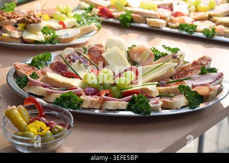 Assorted open-faced sandwiches or canapes topped with herbs and grapes, served on large plates, party snack for the finger food buffet, selected focus Stock Photo