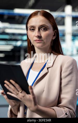 Portrait closeup of data center engineer coordinating backups and recovery protocols using tablet. Server farm employee upgrading IT infrastructure components with device app Stock Photo