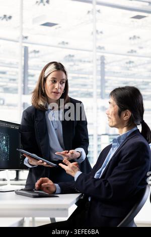 Brainstorming, microchip production and quality control engineers in factory office doing yield enhancement. Overseeing printed circuit boards manufacturing, STEM inclusion and woman with technician Stock Photo
