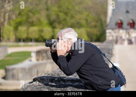 Senior male photographer using a single-lens reflex camera Stock Photo