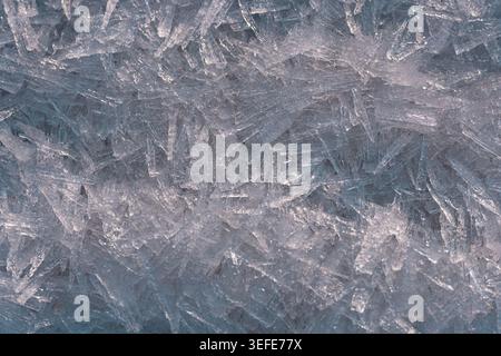 Sharp transparent ice crystal formations creating intricate geometric patterns in a detailed close‑up view Stock Photo