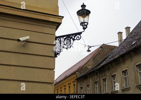 Ornate vintage street lamp and security camera on a building wall in the historic upper town of Zagreb, Croatia Stock Photo