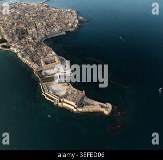 Aerial view of the Island of Ortigia and Maniace Castle surrounded by the turquoise waters of the Ionian Sea in Syracuse, Sicily, Italy. Stock Photo