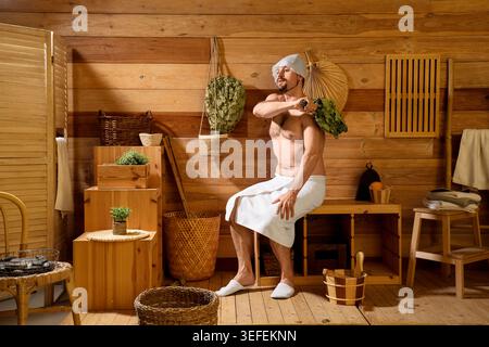 Handsome man with whisk relaxing in sauna Stock Photo