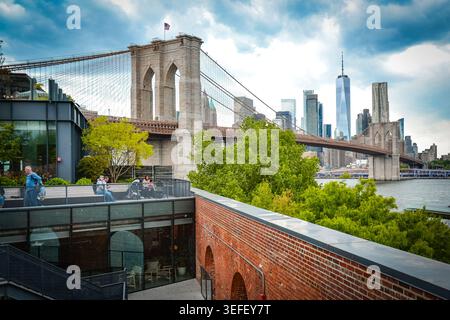 Brooklyn, New York, USA – May 8, 2026: People relaxing on a rooftop terrace overlooking Brooklyn Bridge and Manhattan. Stock Photo