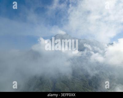 Aerial view of the majestic Mount Merapi volcano rising above a dense ...