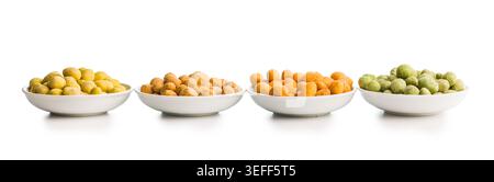 Four white bowls filled with colorful coated peanuts arranged in a row on a clean white background. Vibrant yellow, orange and green snack varieties s Stock Photo
