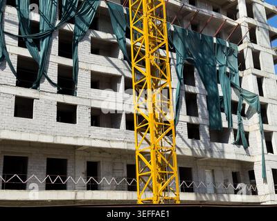 Unfinished house and crane, house under construction, protruding reinforcement, dismantled house, remodeling, new building under construction, concret Stock Photo