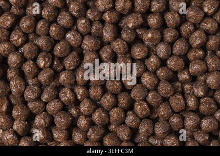 Chocolate breakfast cereal texture. Cereal balls as background. Chocolate corn balls. Top view Stock Photo