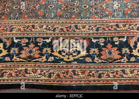 Border of a vintage rug featuring intricate floral motifs, highlighting traditional craftsmanship, color and woven texture for interior decoration Stock Photo