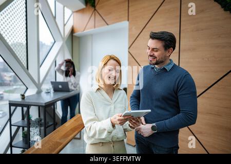 Business colleagues collaborating on digital tablet in modern office Stock Photo