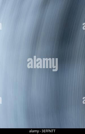 Minimalist abstract background featuring fluid motion blur in shades of steel blue and grey. The brushed texture conveys a sense of speed, energy, and Stock Photo