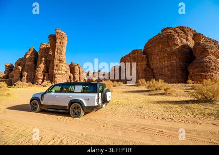 AlUla, Saudi Arabia,Jan 5, 2025: Majestic sandstone mountains in the setting sun at AlUla Sharaan Nature Reserve, viewed from a 4x4 car driving Stock Photo