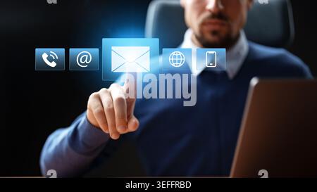 Business professional interacts with digital communication icons on screen Stock Photo