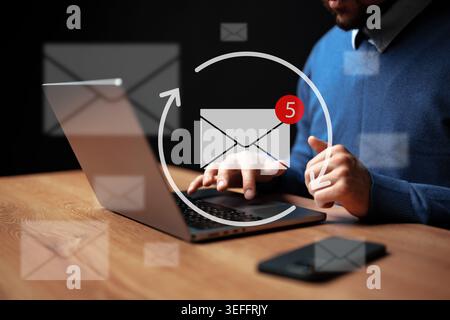 Person checks email on laptop while notifications appear on screen Stock Photo