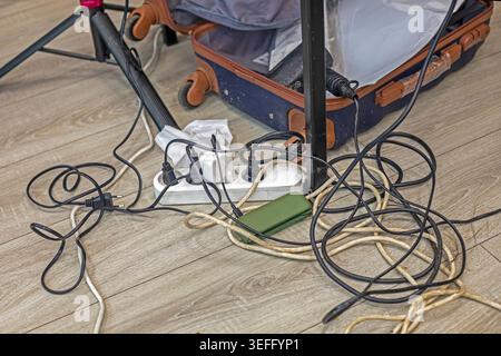 Extension cord with charging devices and cords on the floor in the studio Stock Photo
