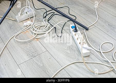 Extension cord with charging devices and cords on the floor in the studio Stock Photo