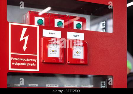 Warsaw, Poland - April 13, 2026: Industrial electrical safety system featuring a red fire emergency power cutoff switch panel with break glass buttons Stock Photo