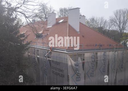 Poznan, Poland - April 13, 2026: The Budch construction site features a house with a fresh red tile roof and metal scaffolding, showcasing professiona Stock Photo