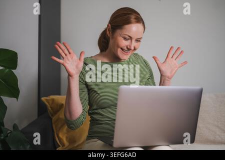 Successful remote work, happy woman celebrating at laptop Stock Photo