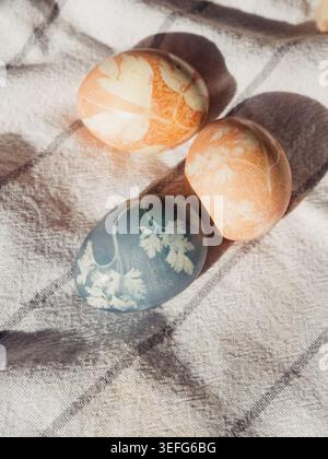 Pastel Easter Eggs with Floral Imprints on White Towel in Sunlight Stock Photo