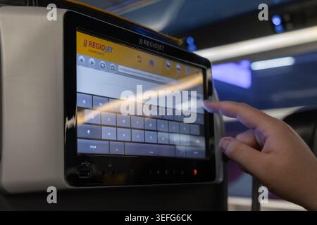 Poznan, Poland - April 13, 2026: RegioJet touch screen display mounted on a seat back in a bus, being operated by a passenger during a trip to access Stock Photo