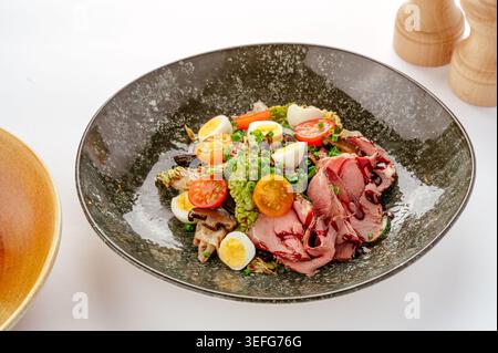Roast beef salad with quail eggs and tomatoes Stock Photo