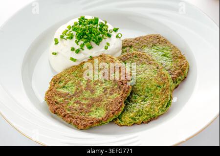 Crispy zucchini fritters with sour cream and chives Stock Photo