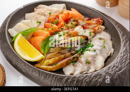 Gourmet assorted fish platter with fresh herbs and lemon Stock Photo