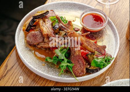 Rack of lamb with roasted vegetables and sauce Stock Photo