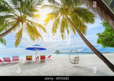 Palm trees and clean, transparent turquoise water on the Beautiful Maldives tropical island. Stock Photo