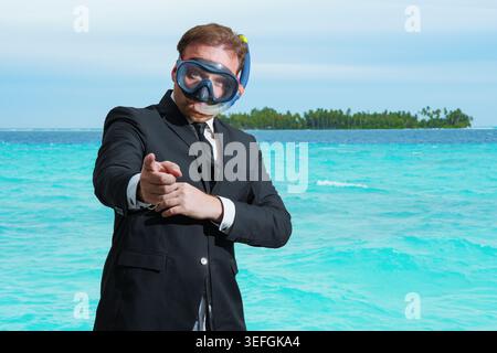 A businessman wearing a diving mask, on a tropical beach during his vacation. A crazy businessman, immersed in a concept of financing and success. Stock Photo