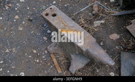 Old Rusty Blacksmith Anvil with Hammer in Workshop Stock Photo