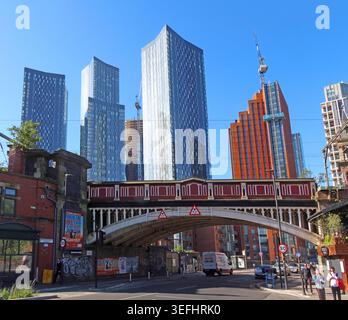 Deansgate, Manchester, with railway bridge and new skyscrapers behind Deansgate station in clear daylight. Stock Photo