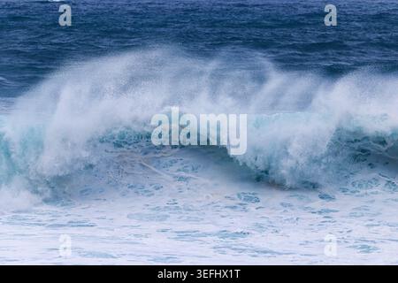 Powerful Turquoise Wave Breaking in the Deep Blue Ocean Stock Photo