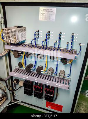 Close-up of neat rows of automatic circuit breakers, terminal blocks, and wiring inside an industrial electrical cabinet. Stock Photo